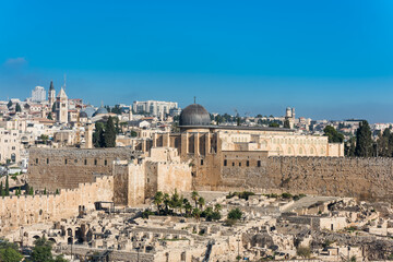 Fototapeta premium Siliver dome of Al-Aqsa Mosque, built on top of the Temple Mount, known as Haram esh-Sharif in Islam and wall of old city of Jerusalem, Israel. View from Mount of Olives.