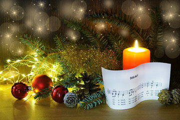 Silent night, candle with sheet music from christmas song, copy space