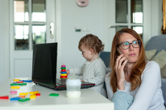 Mom And Baby Working From Home. Lockdown Concept.