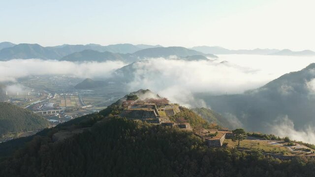 Takeda Castle Ruins, Aerial Establishing Shot with Asago City, Hyogo in the distance of Japan