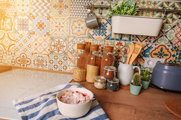 Prepare Breakfast in the modern kitchen with oven-style tiles. Cottage cheese with jam. Kitchen utensils and jars of cereals