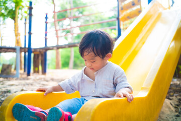 Toddler preschool boy playing slider outdoor park