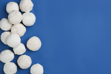 Snowballs on blue background, flat lay. Space for text