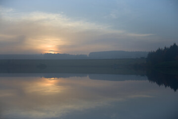 Dusk sunset over redmires reservoirs with hazy and calm conditions
