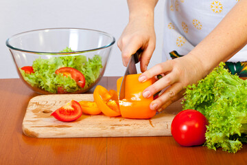 Women's hands are preparing a salad