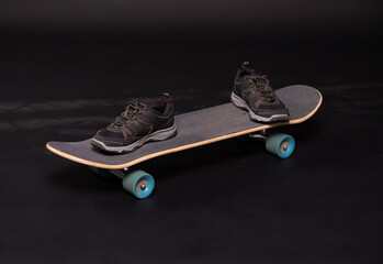 A pair of sneakers is on a skateboard © smallblackcat