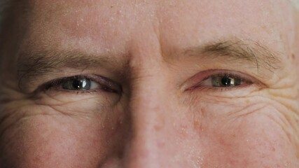 Face of happy elderly middle aged man smiling with friendly blue eyes. Handsome mature male senior citizen with wrinkles on attractive face looking and laughing at camera.  Macro extreme close up, 4K. - Powered by Adobe