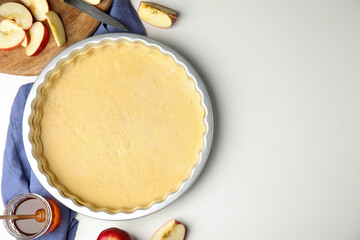 Raw traditional English apple pie and ingredients on white table, flat lay. Space for text