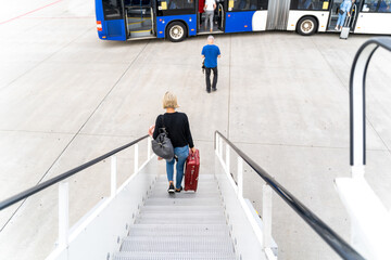 Passengers at the airport with laggage getting off a plane