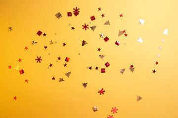 Christmas sparkles in the form of a Christmas tree, gifts, stars on a yellow background. High quality photo