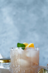 Vertical view of brown cocktail with fresh mint and orange