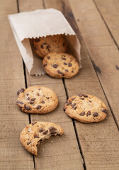 Chocolate chip cookies on a paper bag over a wooden table