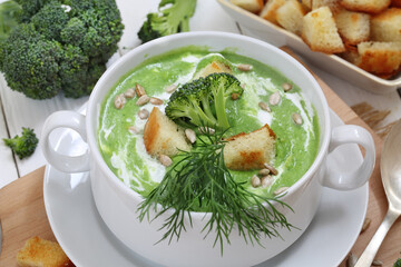 Soup puree with broccoli in white soup stock on a wooden background