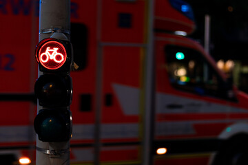 Gefahren im Verkehr für Radfahrer veranschaulicht durch den Kontrast einer roten Ampel und dem...