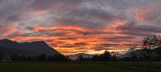Suggestivo tramonto sul lago in autunno, con nuvole colorate di rosa, rosso e arancione. Immagine molto bella.  © fotonaturali