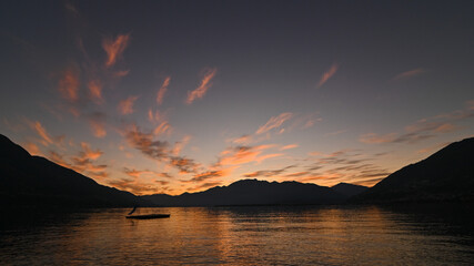 Suggestivo tramonto sul lago in autunno, con nuvole colorate di rosa, rosso e arancione. Immagine molto bella.  © fotonaturali
