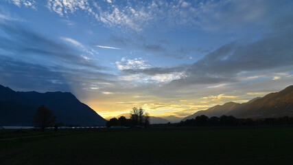 Suggestivo tramonto sul lago in autunno, con nuvole colorate di rosa, rosso e arancione. Immagine molto bella.  © fotonaturali