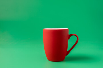 Big red mug on green background, horizontal.