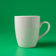 Big white mug on green background, horizontal.