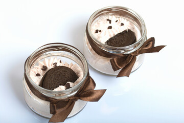 Marshmallow in a jar. With cookies and chocolate. On a white surface.