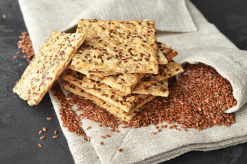 Stack of multigrain crispbread with flax seeds on linen napkin background.