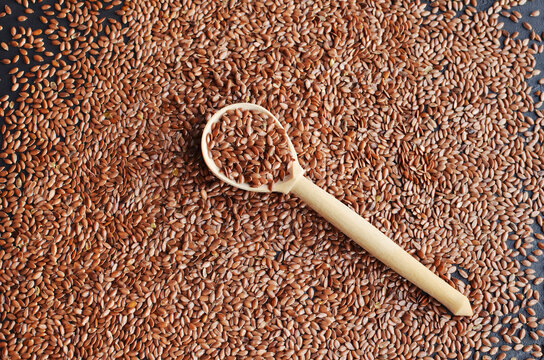 Organic flax seeds in wooden spoon.