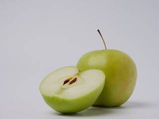 A green Apple fruit with a green Apple half isolated on a white background. Green apples with a cropped path. Full depth of field