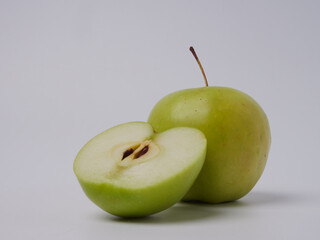 A green Apple fruit with a green Apple half isolated on a white background. Green apples with a cropped path. Full depth of field