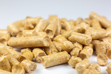 Wood pellets texture. Wooden pet bedding on white background. Close up photo.