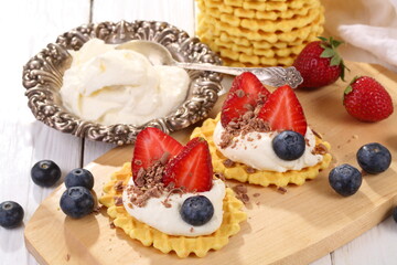 Mascarpone cheese with strawberries and blueberries on a white wooden table