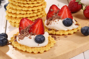 Mascarpone cheese with strawberries and blueberries on a white wooden table