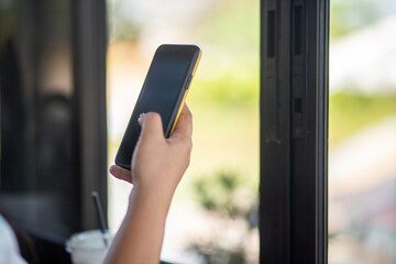 Close up of a woman using a mobile phone in a cafe