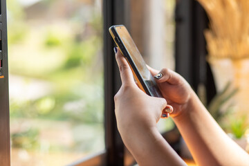 Close up of a woman using a mobile phone in a cafe