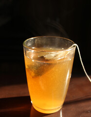 glass of lemon and tulsi tea with tea bag