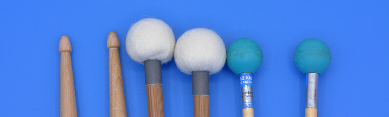 Percussion mallets set on a blue rectangular frame background.