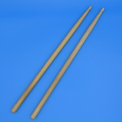 Percussion drumsticks on a blue background.