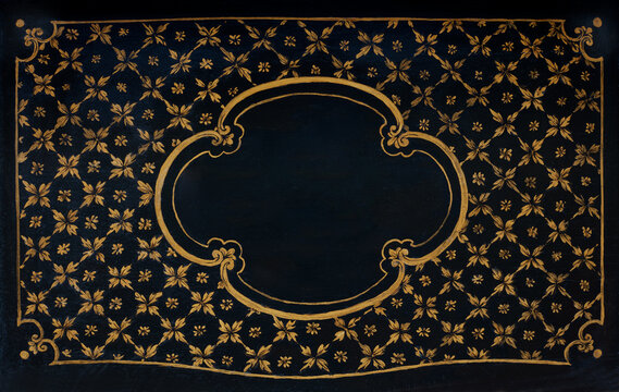 Old, golden floral frame painted on black wooden texture background