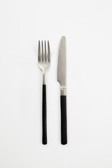 Black silver or steel cutlery view from above on a white background. Top view..Knife and fork for a festive table for a wedding, birthday or party.