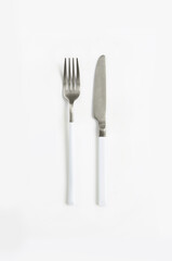 White silver or steel cutlery view from above on a white background. Top view..Knife and fork for a festive table for a wedding, birthday or party.