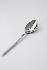 Silver or steel cutlery on an isolated background. Gilded teaspoon of white color. Top view.