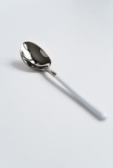 Silver or steel cutlery on an isolated background. Gilded teaspoon of white color. Top view.