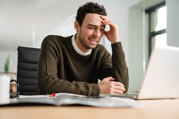 Stressed business man looking at laptop