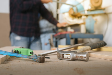 Carpenter working with equipment on wooden table in carpentry shop. woman works in a carpentry shop.