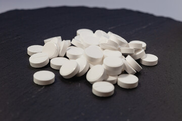 White pills, drugs on grey background. Prevention of coronavirus. Web banner on site with empty space for text on the left side. Isolated. Medical preparations close up