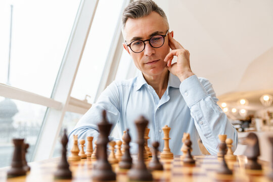 Confident focused business man playing chess