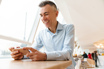 Confident handsome businessman using smartphone