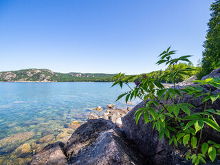 Point de vue d'un lac avec des pierres en avant plan en été