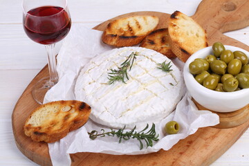 Camembert with toasted baguette on white background