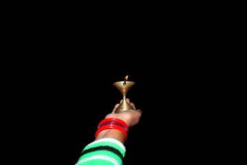 A brass lamp burning in the hands of the ladies