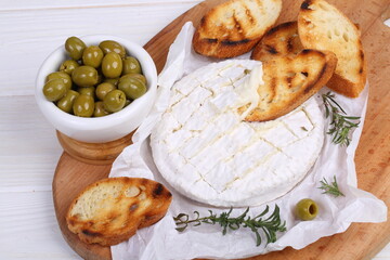 Camembert with toasted baguette on white background